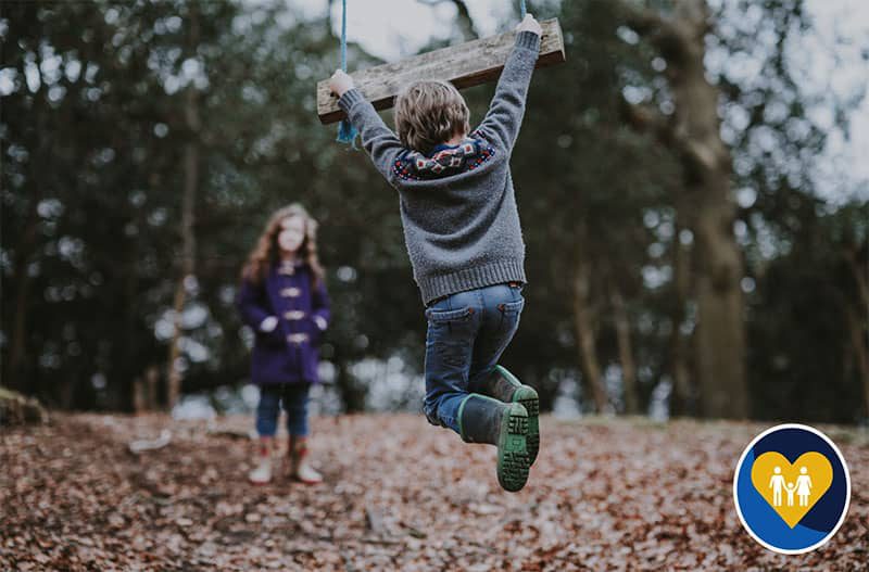 Children jumping in autumn leaves