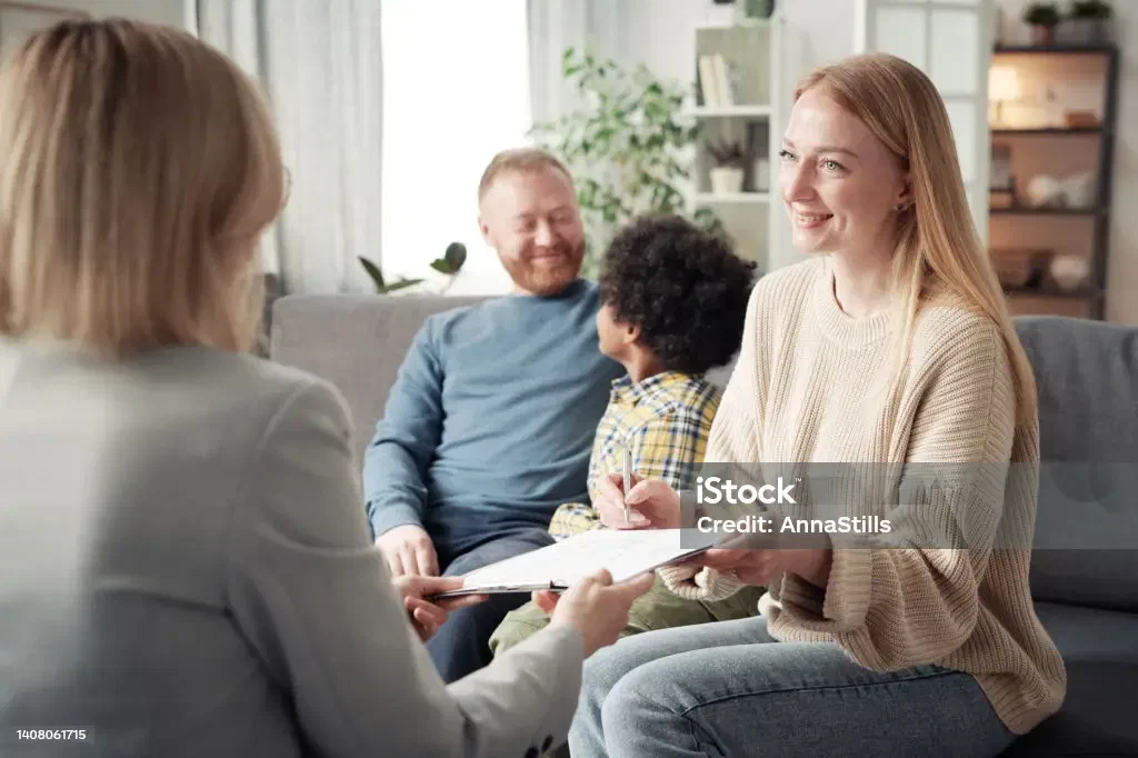 A family signing adoption paperwork