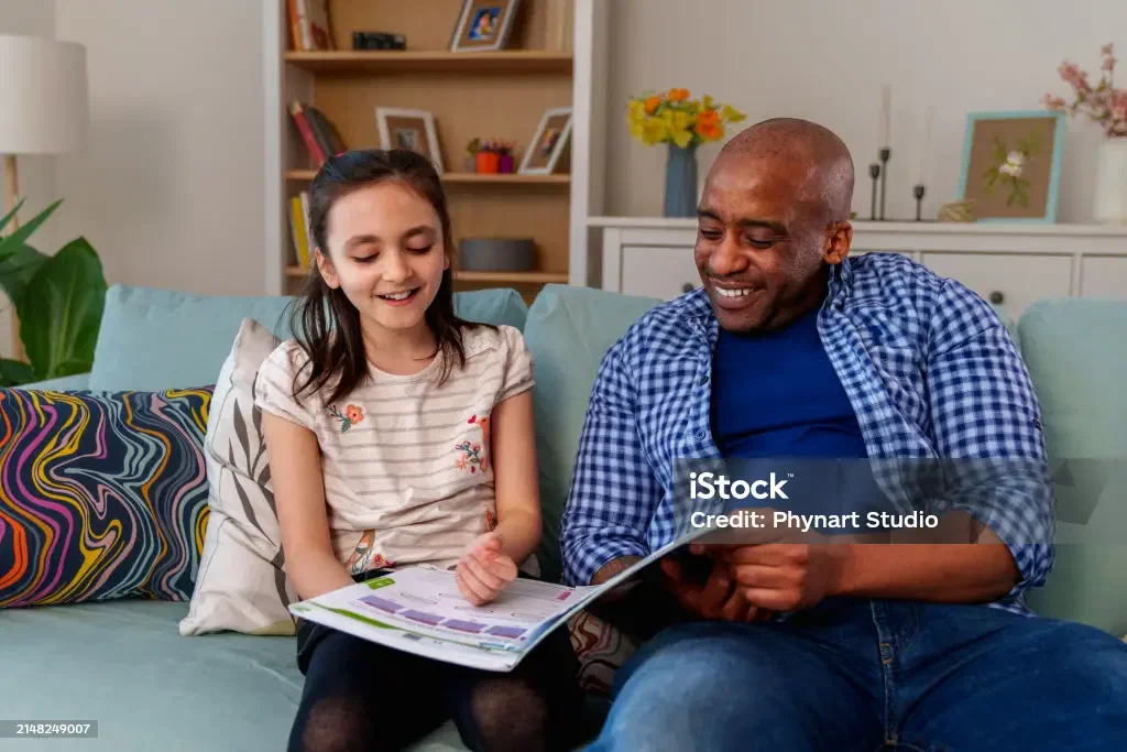 A father reading a book to his adopted daughter