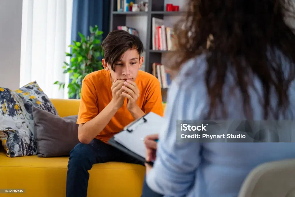 A psychologist counseling a teenage boy