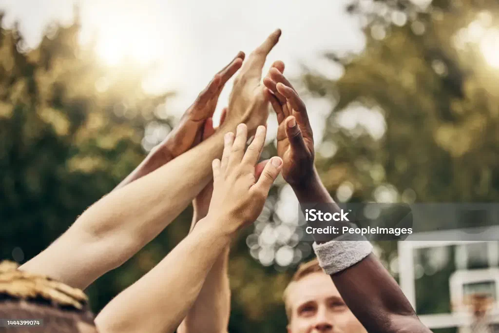 A coach and a youth basketball team high-fiving
