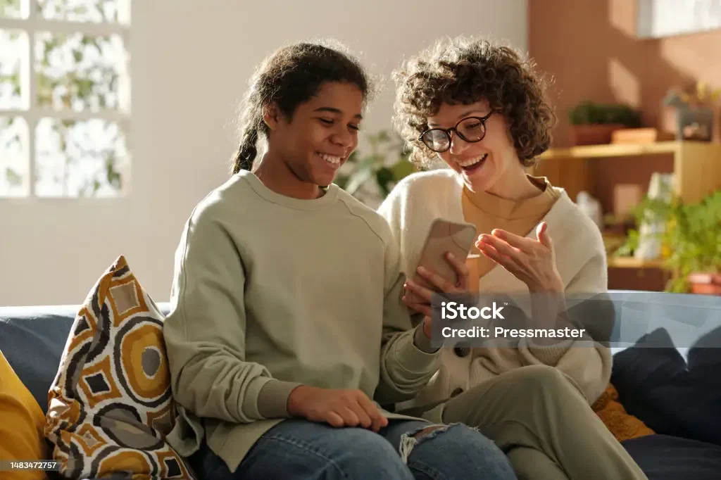 A mother spending time with her adopted teenage daughter at home