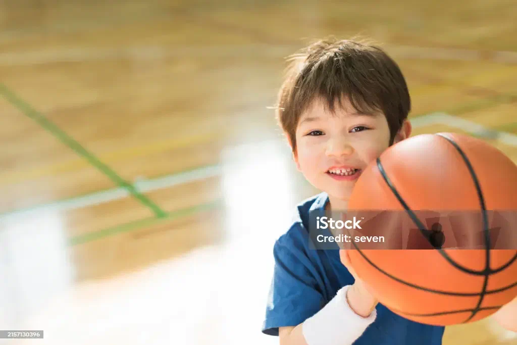 Teens playing basketball in the Wolverine Center gym
