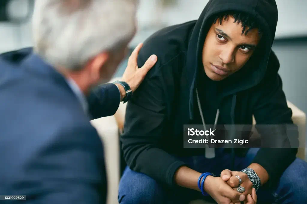 A therapist encouraging a teenage boy during a session
