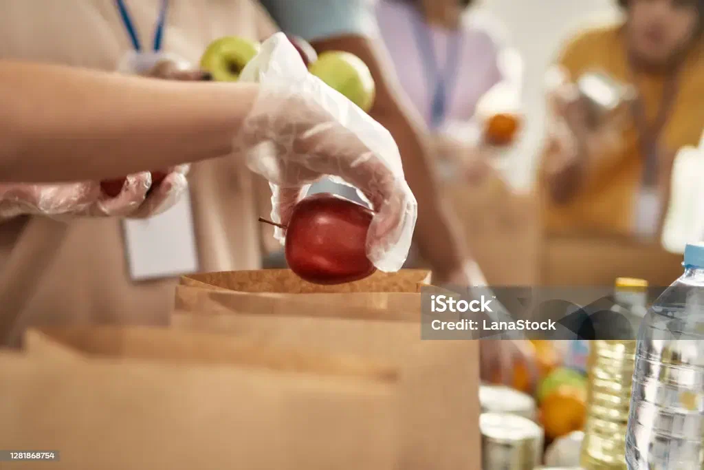 A volunteer's hand holding an apple at Core Orchards